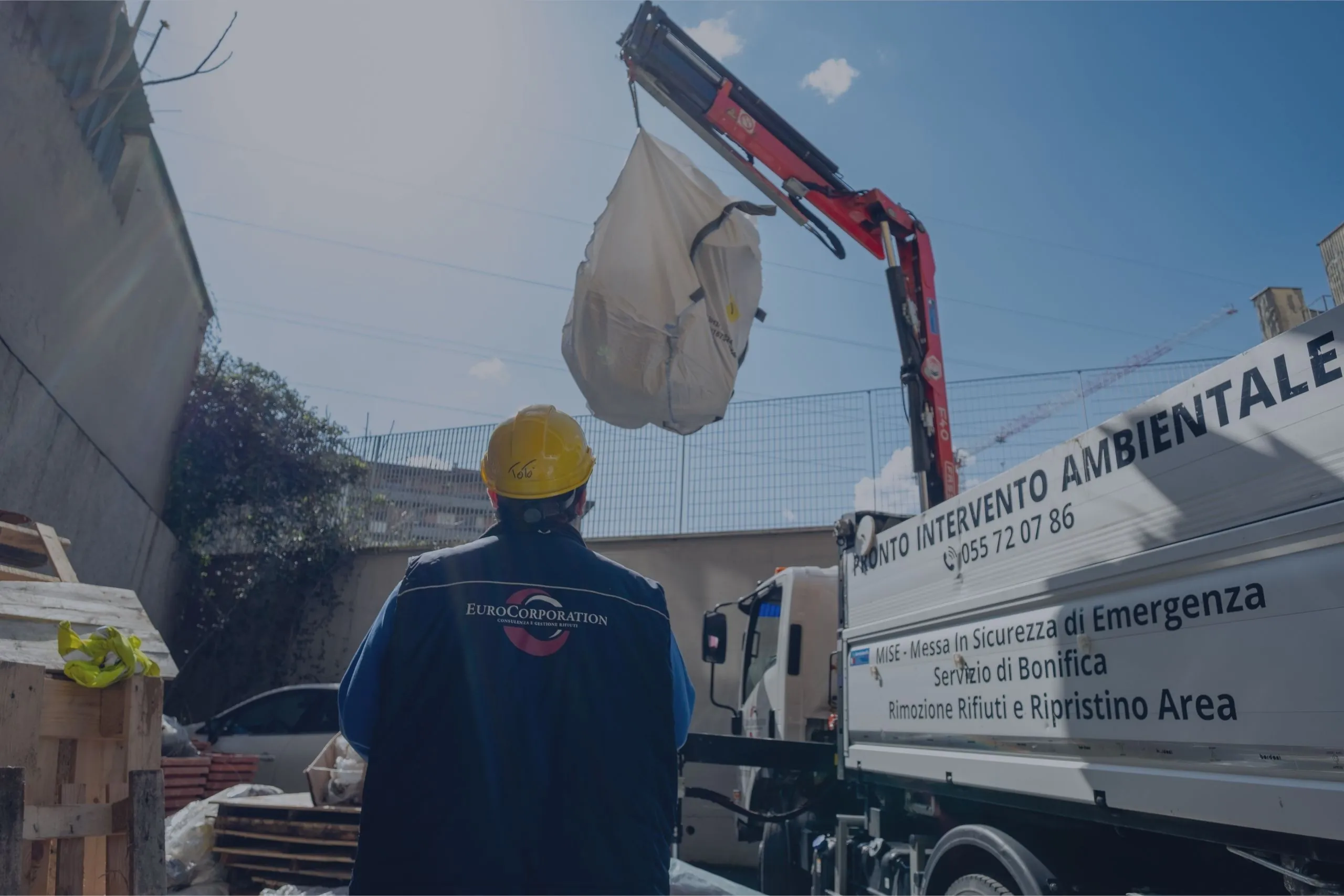 Operatore EuroCorporation con casco di sicurezza durante ritiro rifiuti con gru e big bag in cantiere